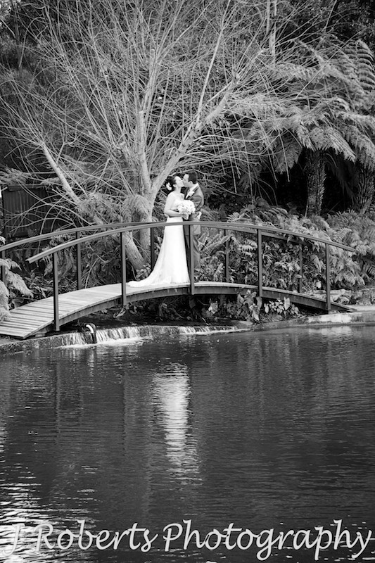 B&W bride and groom kissing on a bridge - wedding photography sydney